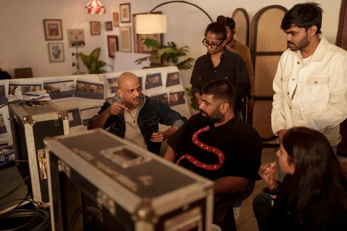 Devang Singh going through a storyboard wall with his team on set